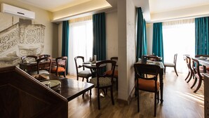 Un espace repas avec des meubles en bois et un escalier agrémenté de rampes décoratives.