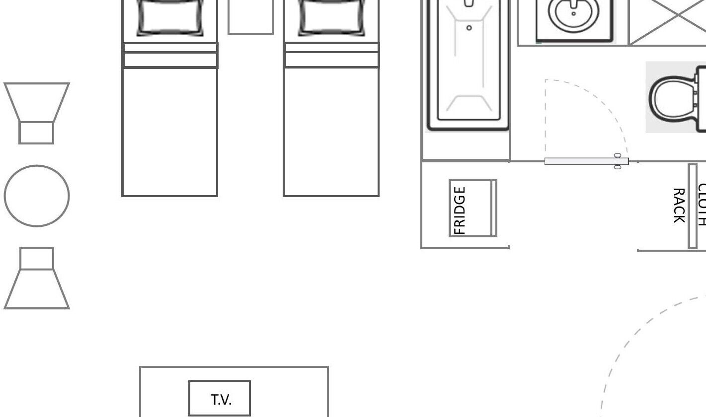 Ein Grundriss eines Hotelzimmers mit Bad, Fernseher und einer Küchenzeile.