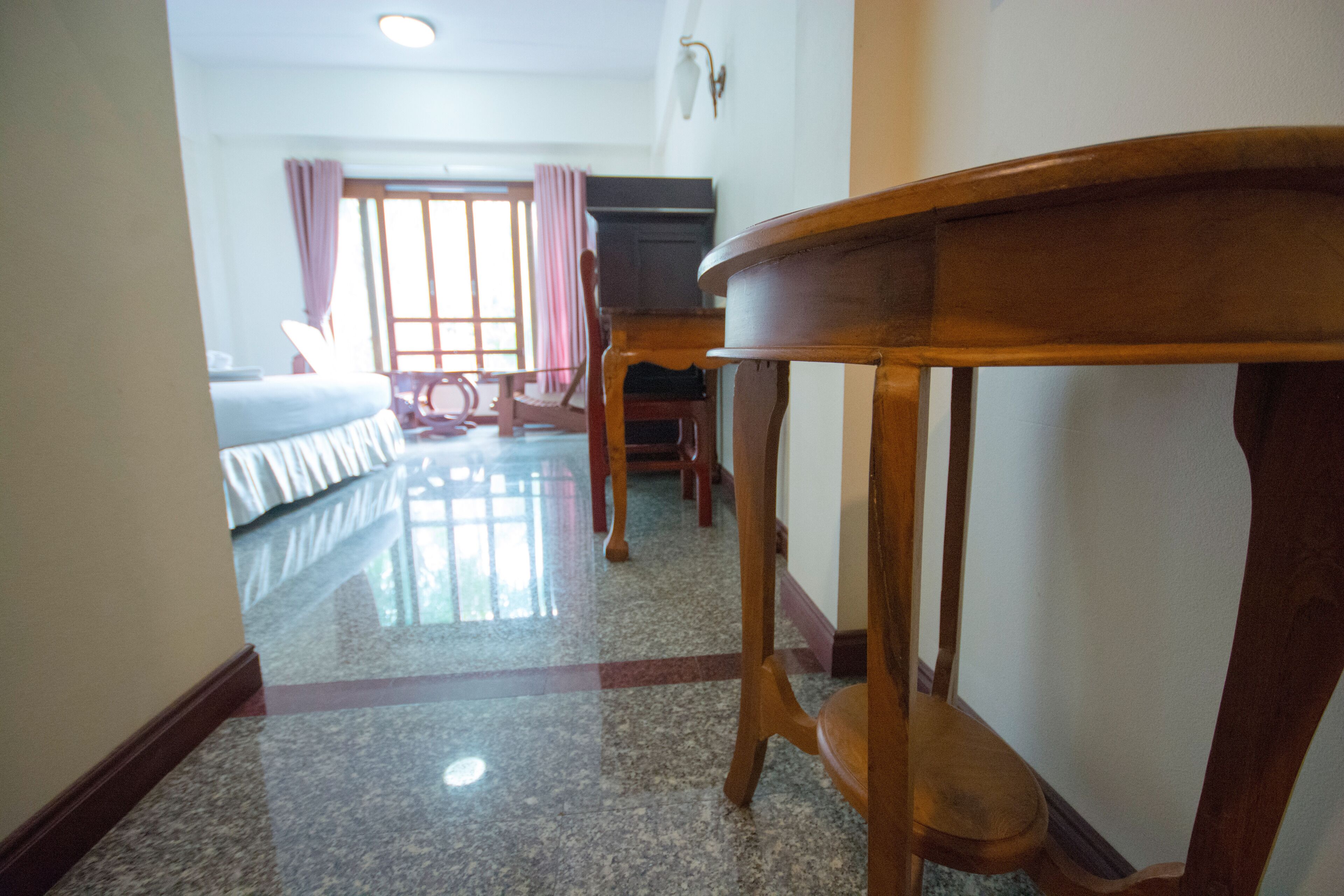 Una habitación de hotel con una cama, una mesa de madera y una silla.
