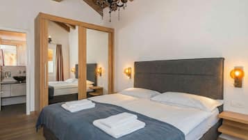Un dormitorio moderno con una cama grande, cabecera de madera y lámparas de noche.