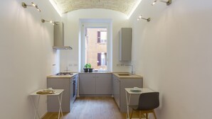 Una cocina compacta con una isla central, un pequeño comedor y vistas por una ventana.