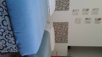 Une pièce avec des rideaux à motifs, un mur orné de tableaux encadrés et une fenêtre bien visible.