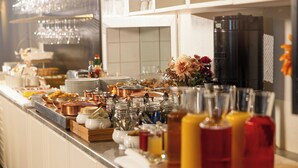 A buffet setup with various food items, utensils, and beverages. - Hotell Gillet i Köping (Köping)