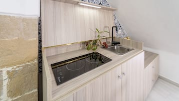 Una cocina moderna con estufa integrada, un lavabo y armarios de madera.