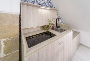 Una cocina moderna con estufa integrada, un lavabo y armarios de madera.