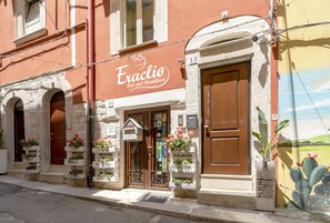 A building with a sign reading "Eraclio Bed and Breakfast" and a door with a window above it.
