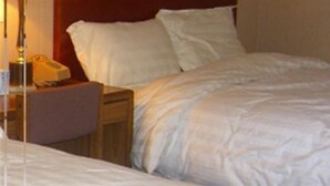 A hotel room with a bed, a nightstand, and a telephone. - Motel 88 (Oneonta)
