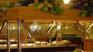 A buffet area with a glass enclosure and metal railings. - Motel 88 (Oneonta)