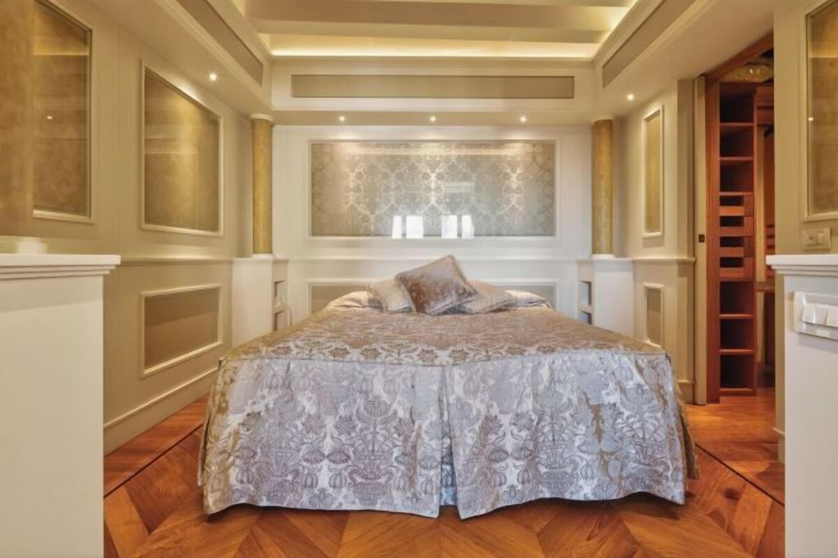Une chambre dotée d’un grand lit, d’une armoire intégrée et d’un panneau décoratif mural.