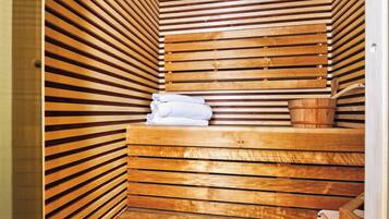 Un sauna en bois avec des parois à lattes, un banc en bois et un seau.