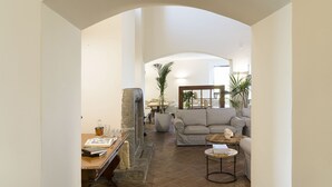 Un vaste espace de vie agrémenté d’une cheminée en pierre, d’un canapé et d’une table basse.