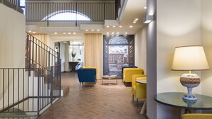 Un vaste espace intérieur comprenant un escalier, un coin salon et un mur décoratif agrémenté d’une fenêtre.