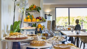 Un buffet de petit-déjeuner proposant un assortiment de viennoiseries et de fruits.