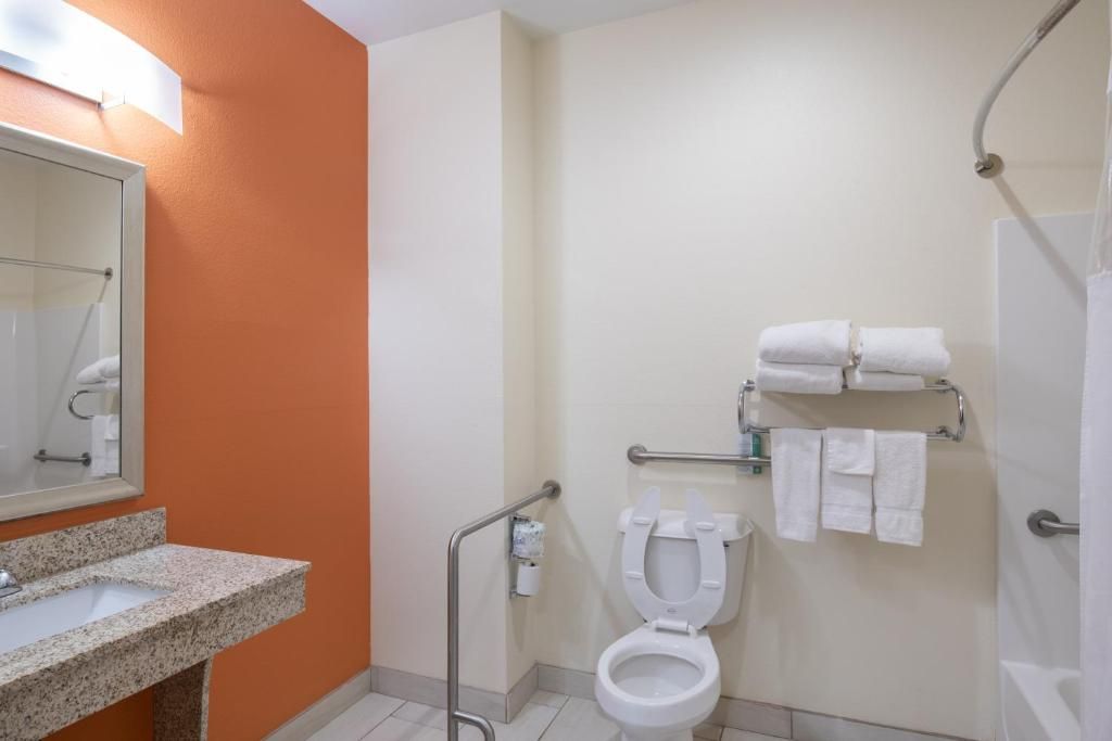 Un bany amb un lavabo, vàter i zona de dutxa.