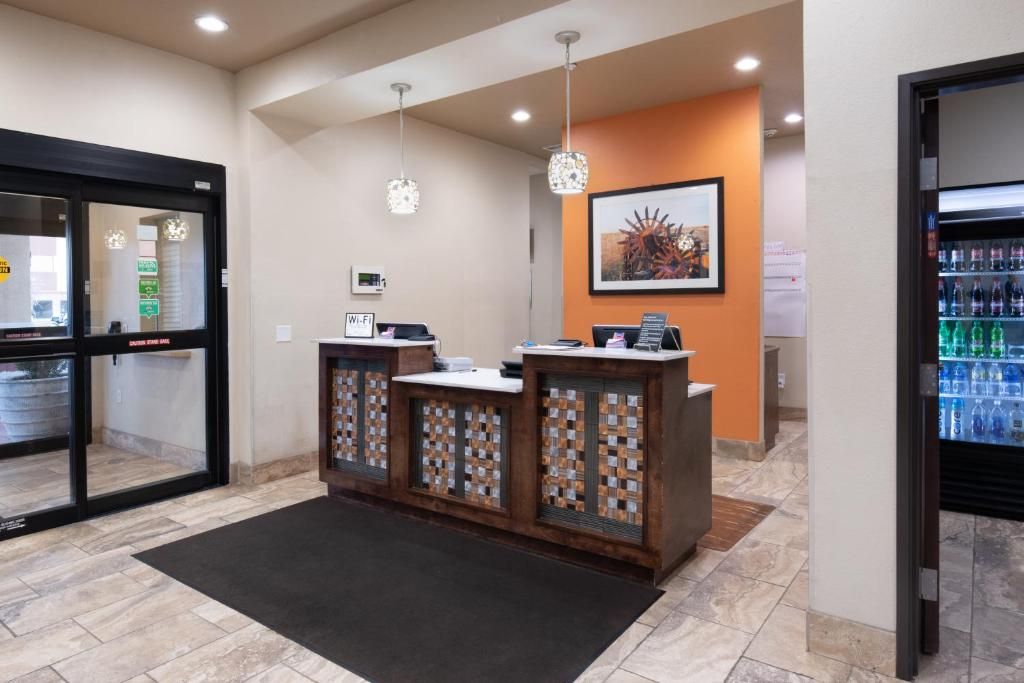A reception area with a counter, a framed picture on the wall, and a refrigerator stocked with beverages.