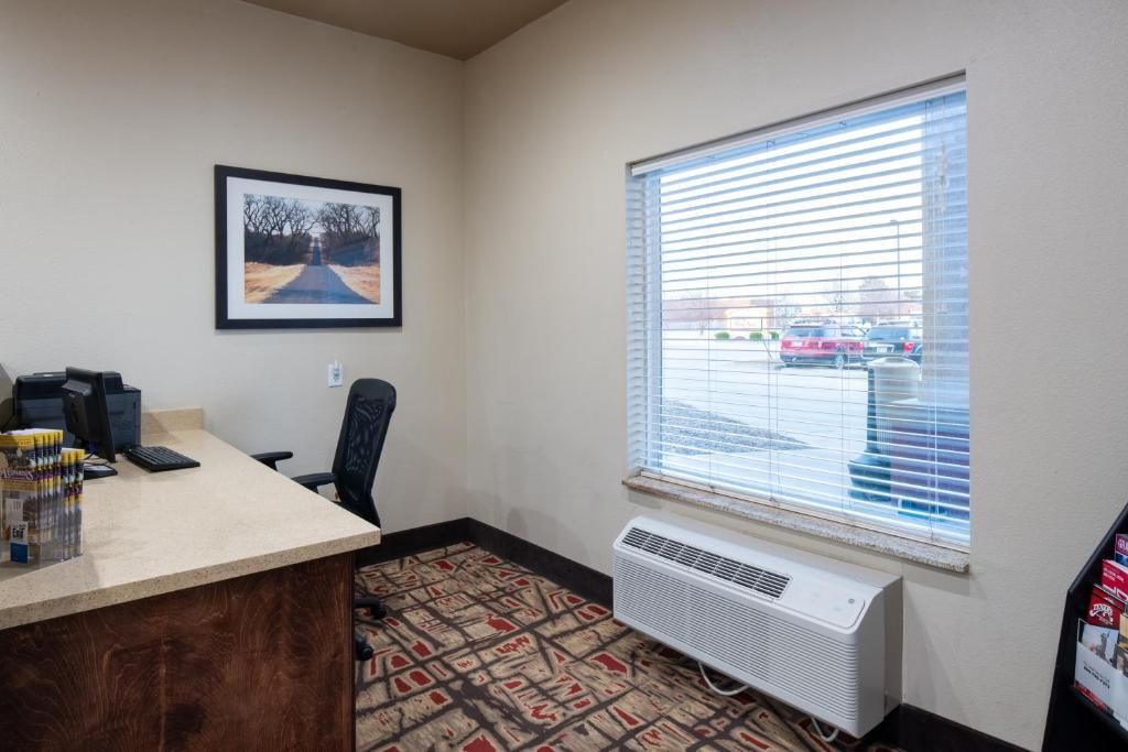 A room with a desk, computer, and air conditioning unit.