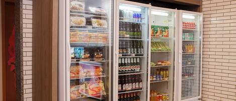 A row of refrigerated display cases in a store, containing various food items and beverages.