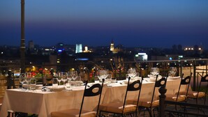 Une table dressée pour un repas, avec une vue sur la ville en arrière-plan.