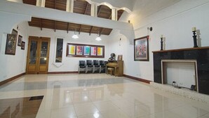 A spacious lobby with a high ceiling, a fireplace, and several framed artworks on the walls. - Hotel Ave del Paraíso (Mercedes)
