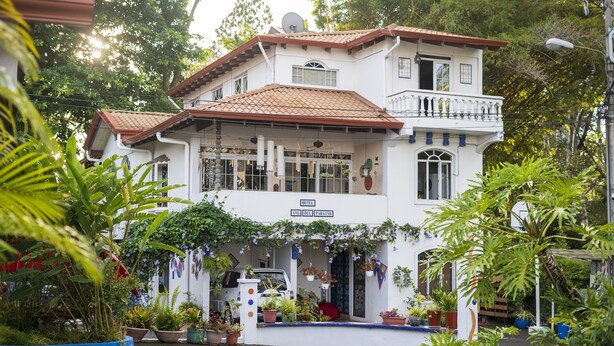A white building with a red-tiled roof, a balcony, and a sign that reads "HOTEL." - Hotel Ave del Paraíso (Mercedes)