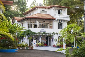A white building with a red-tiled roof, a balcony, and a sign that reads "HOTEL." - Hotel Ave del Paraíso (Mercedes)