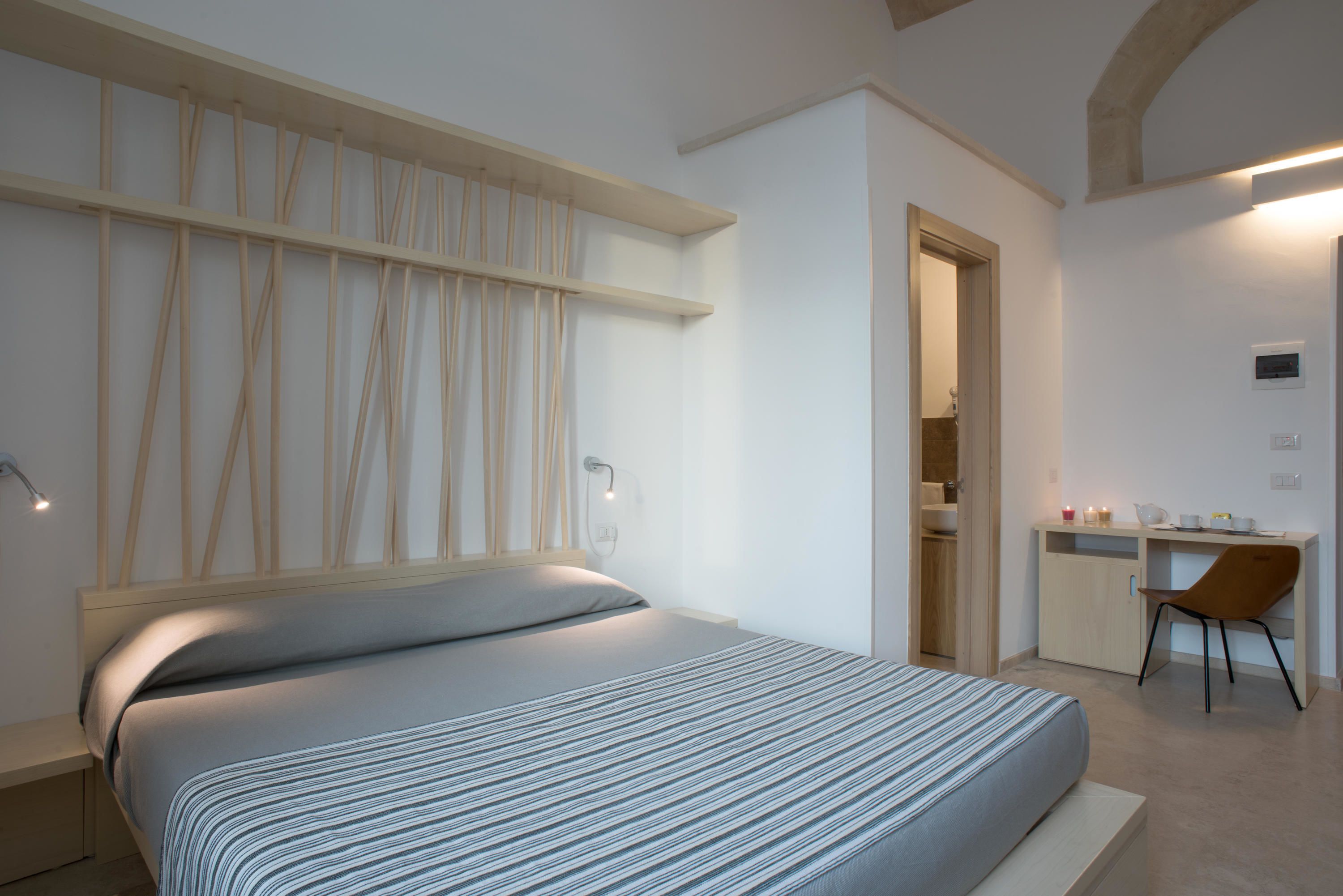A modern bedroom with a bed, a desk, and a chair.