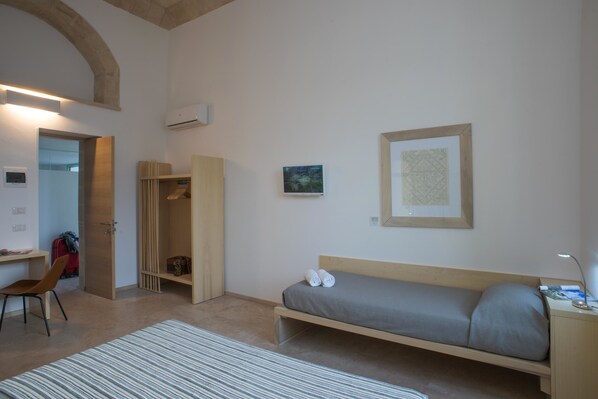Una habitación con cama, escritorio, silla y armario.