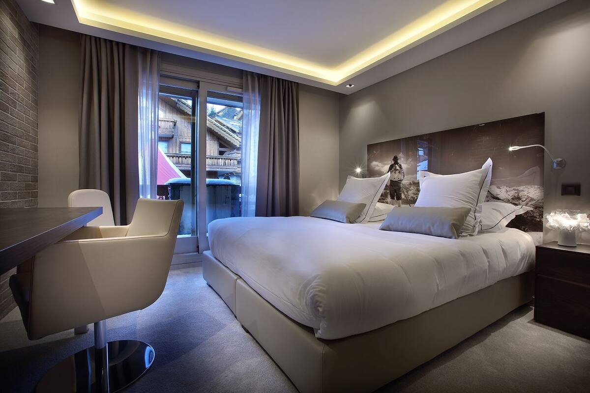 Een moderne hotelkamer met een groot bed, een bureau en een stoel.