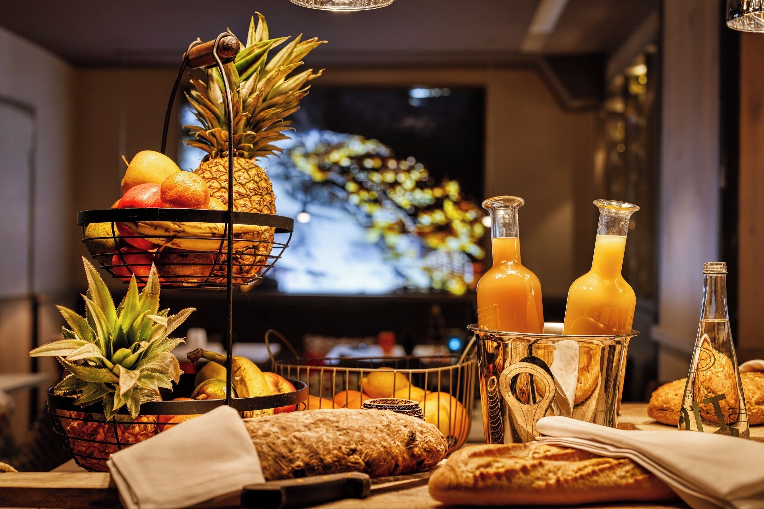 A breakfast buffet with fruits, bread, and juice bottles.