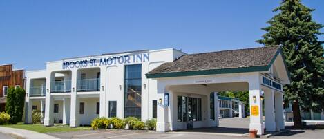 Un motel con un letrero que dice 'Brooks St. Motor Inn' y una zona de estacionamiento techada.