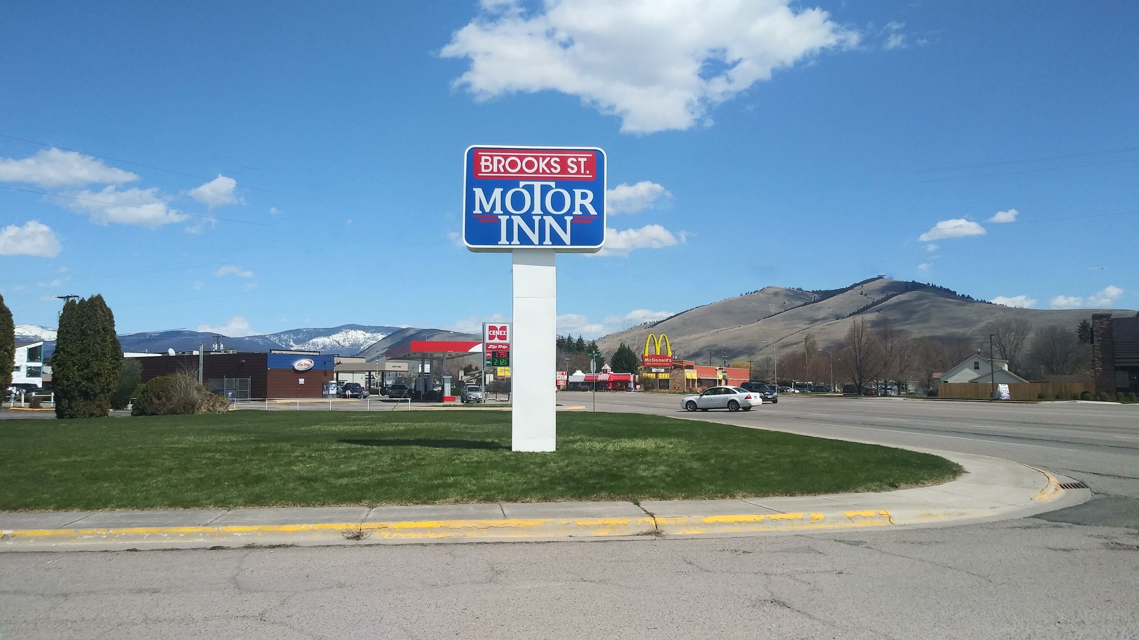 Skilt for Brooks St. Motor Inn med udsigt til et tankstation og en McDonald's i baggrunden.