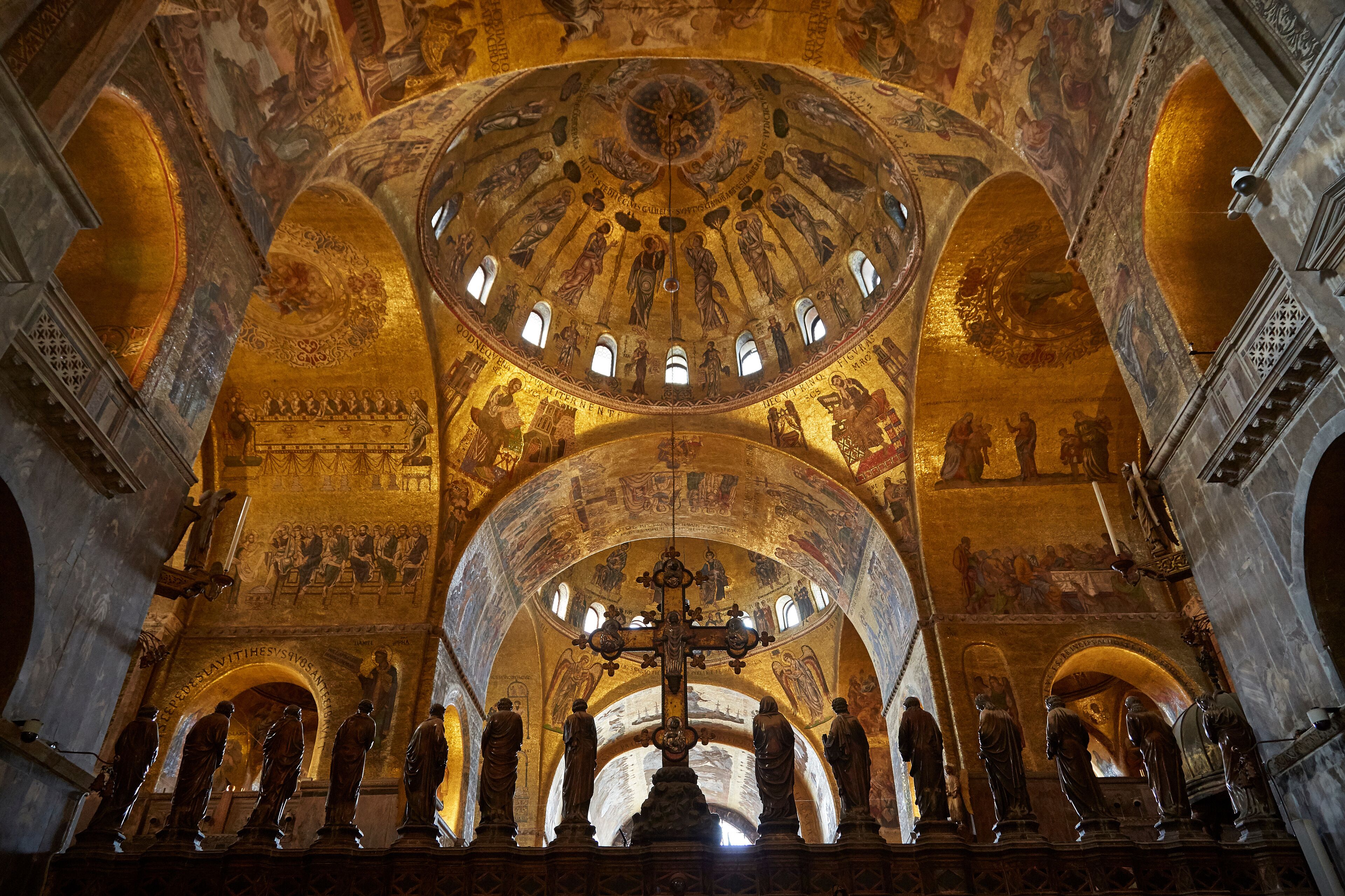 Un interior imponente con un gran techo abovedado, ventanas de arco y frescos detallados.