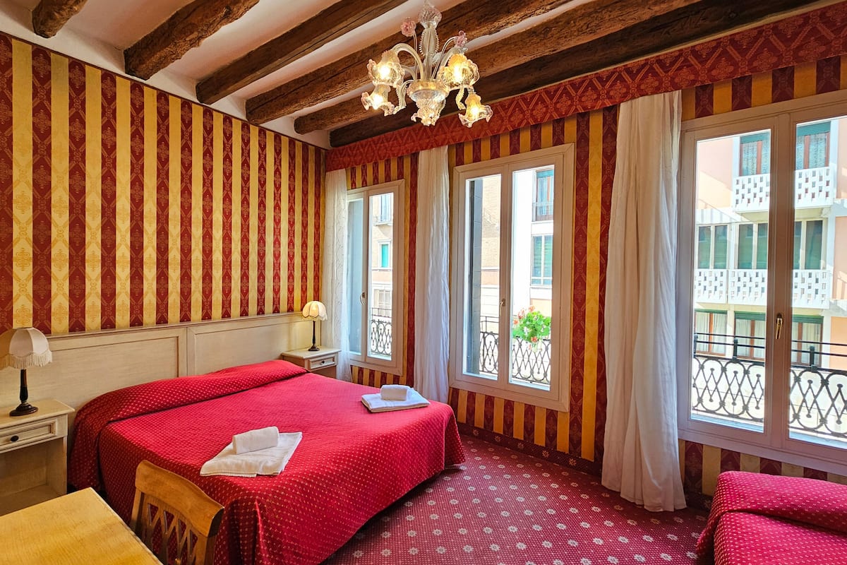 Habitación cuádruple Deluxe, vista al canal | Sábanas italianas Frette y ropa de cama de alta calidad