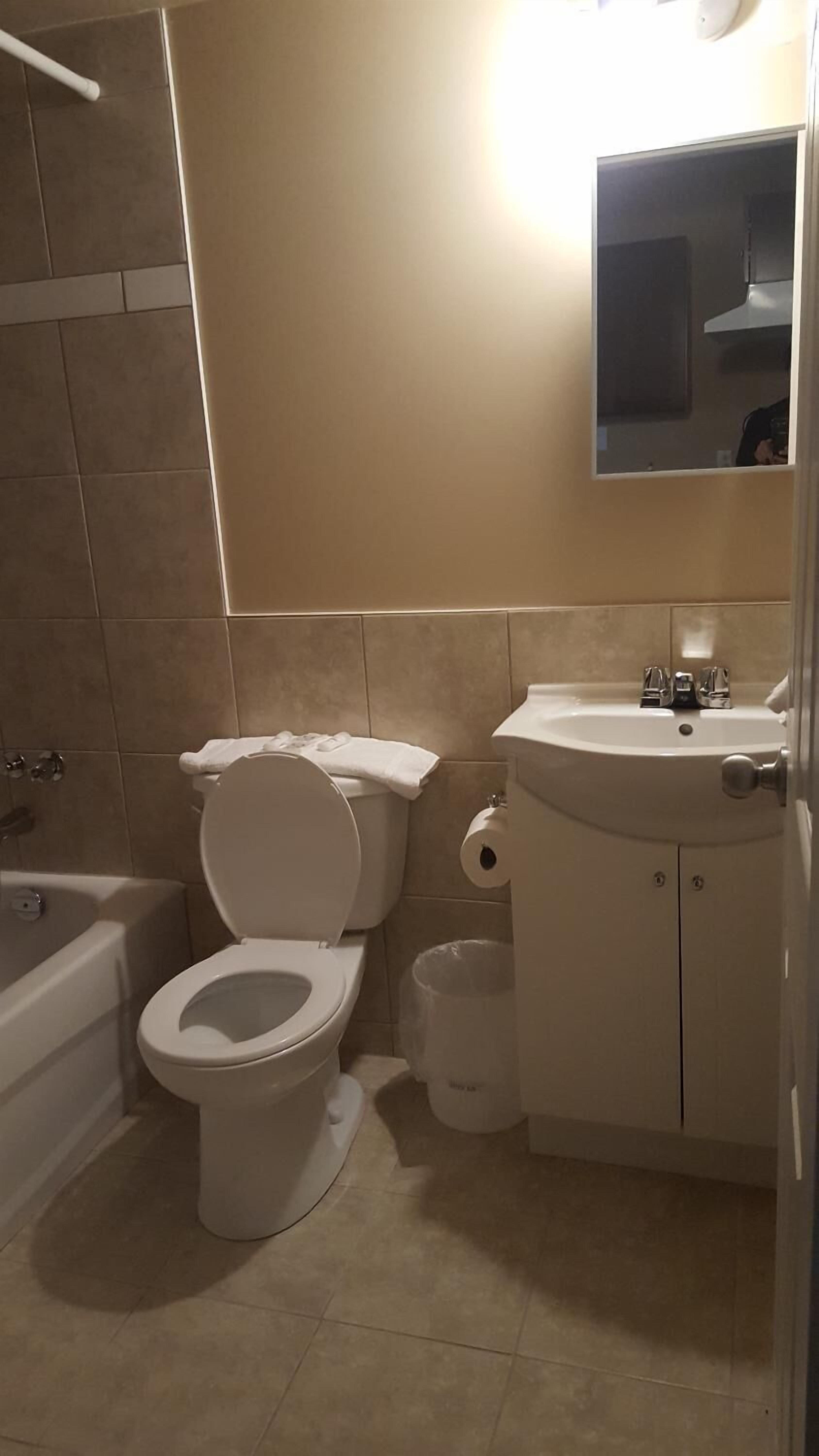Een bad/douchecombinatie, handdoeken