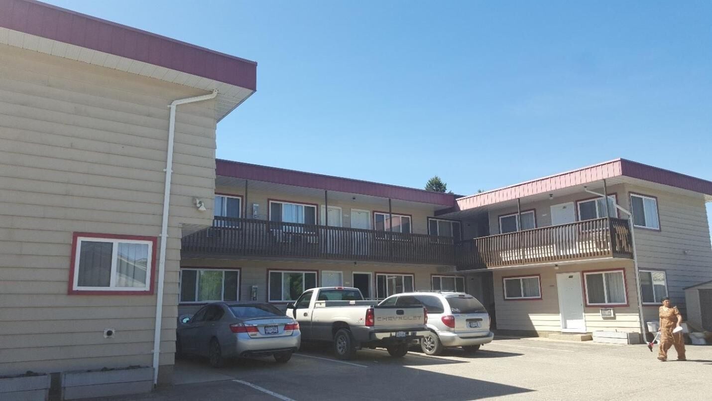 Een motel met meerdere verdiepingen en een parkeerplaats.