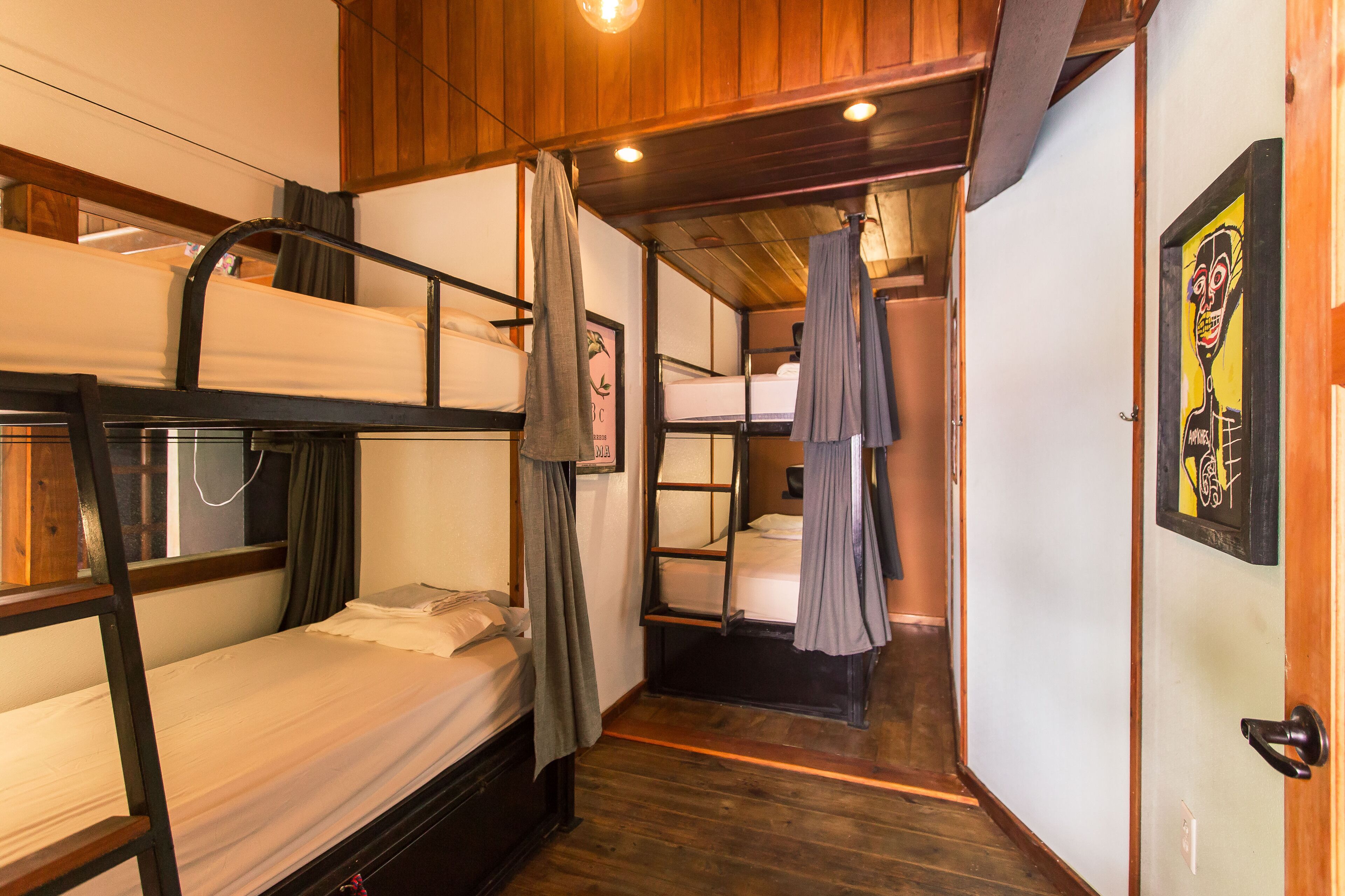 Una habitación con literas, paredes de madera y una puerta con un dibujo.