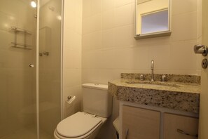 A bathroom with a toilet, sink, and shower. - Caneca SP 101 (São Paulo)