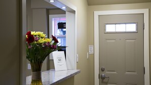 Un espace d’accueil comprenant un comptoir de réception, un vase de fleurs, un panneau indicateur et une porte.