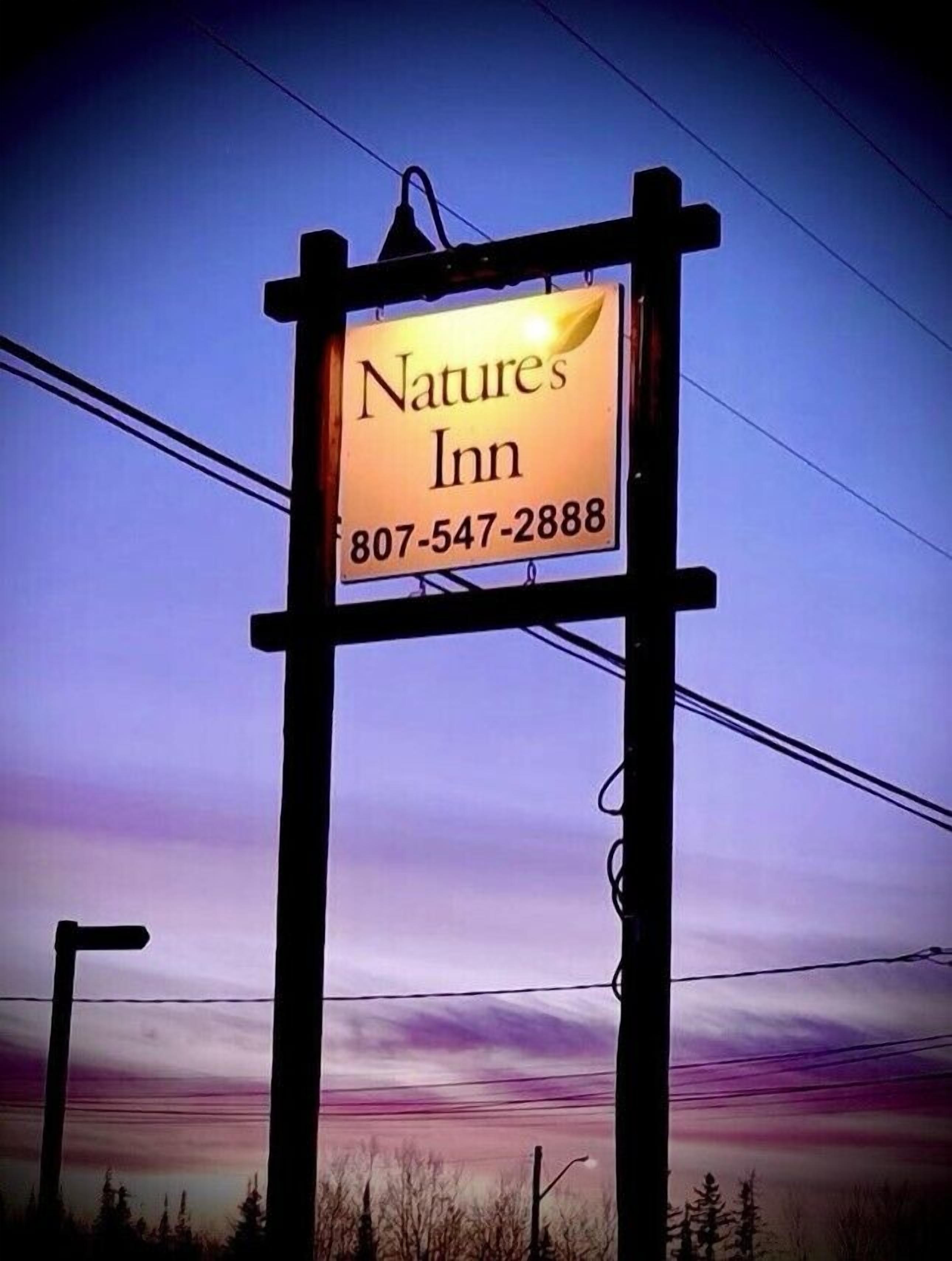 A sign for Nature's Inn with a contact number.