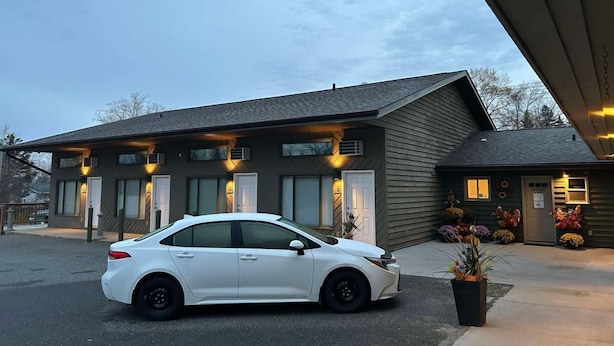 Un bâtiment moderne avec une voiture garée devant.
