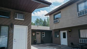 A two-story building with a front door, a small office, and a covered patio area.