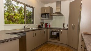 A modern kitchen with a dishwasher, microwave, oven, and stainless steel appliances.