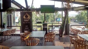 A restaurant with outdoor seating, a sign for Hotel Russia, and a view of the street. - Russia Hotel Skopje (Skopje)