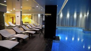 Un espace aménagé au bord de la piscine, avec des chaises longues et une piscine.