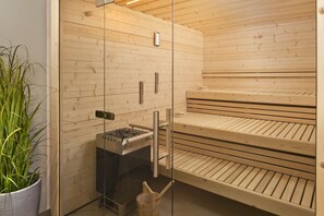 Un sauna con bancos de madera y puerta de vidrio.