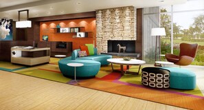 Relax in the hotel lobby with a variety of seating options, including a sofa, coffee table, and ottoman.