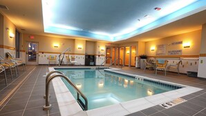 An indoor swimming pool with clear water, tiled floor, and safety signs. - Fairfield Inn & Suites by Marriott Madison Verona (Verona)