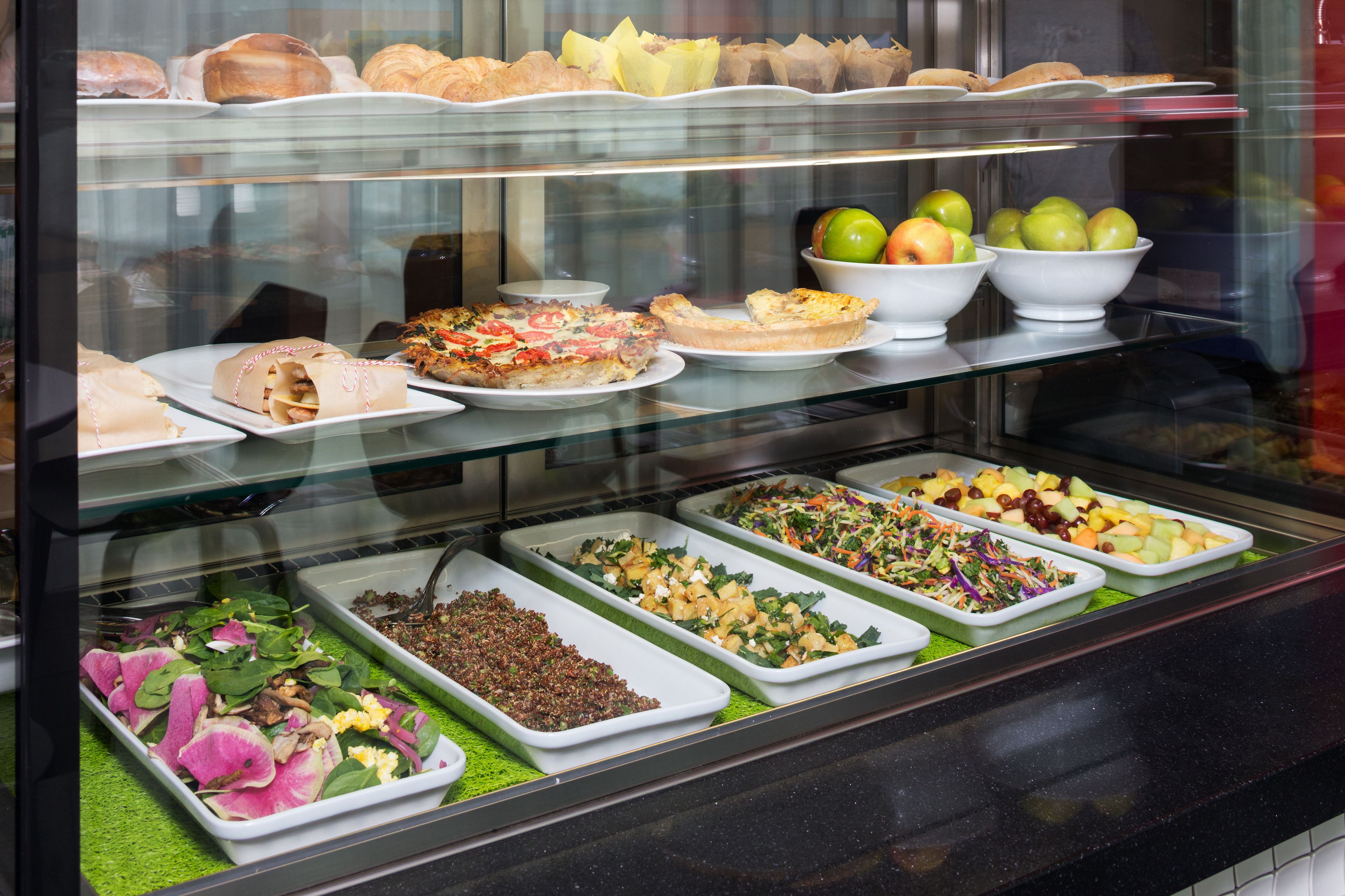 A buffet with various food options including salads, fruits, and pastries.