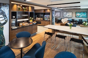 A modern hotel lobby with a central seating area, a reception desk, and a buffet counter. - Hyatt Regency Bloomington - Minneapolis (Bloomington)