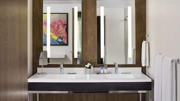 A modern bathroom with a double sink, a large mirror, and a wooden panel design.